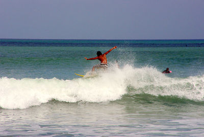 Man surfing in sea against clear sky