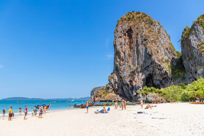 People at beach against blue sky