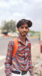 Portrait of young man standing against sea