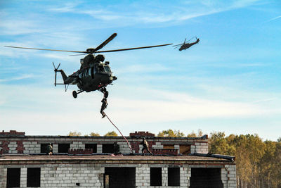 Low angle view of helicopter flying in sky