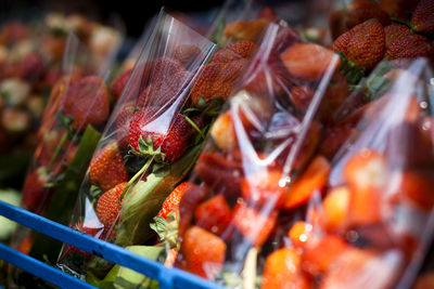 Strawberries in plastic bags at market stall