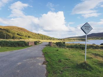 Road passing through scottish highland landscape against sky