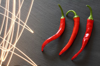 High angle view of red chili peppers with light painting on slate