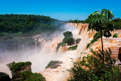 Scenic view of waterfall against sky