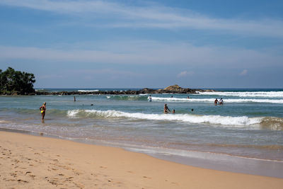 People on beach against sky