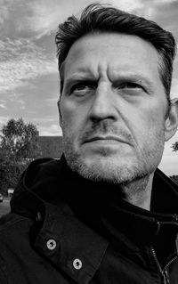 Close-up of thoughtful man looking away against sky