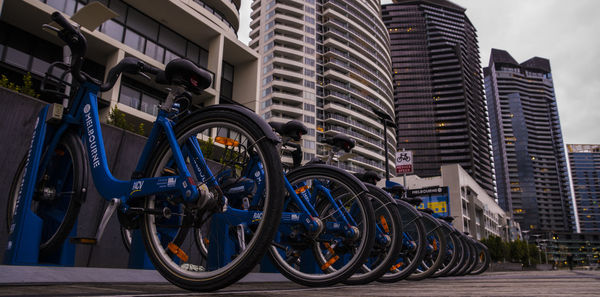 Bicycles parked on road by buildings in city