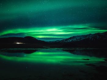 Scenic view of lake against sky at night