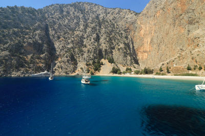 Boats on sea against mountain