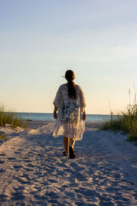 Rear view of woman walking on beach