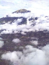 Aerial view of snow covered land and clouds