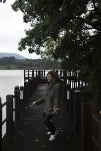 Portrait of young woman walking on footbridge at the seaside 