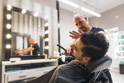 Barber shaving beard in salon