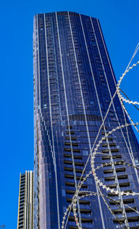 Low angle view of modern building against clear blue sky