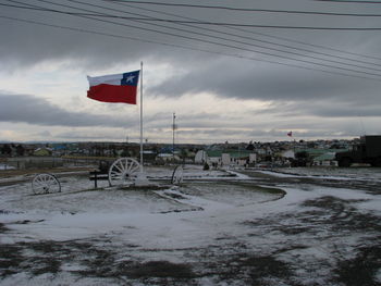 Flag on beach against sky
