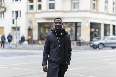 Portrait of smiling man standing on street in city