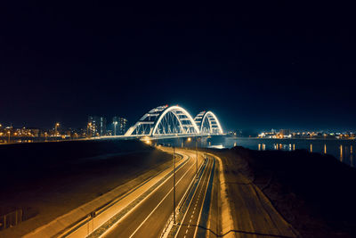 Light trails on road against sky at night