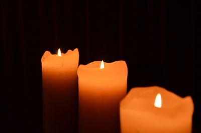 Close-up of burning candle in darkroom