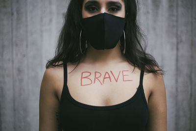 Portrait of woman standing against wall