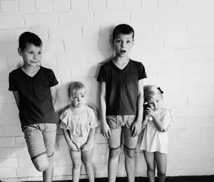 Portrait of happy siblings against wall