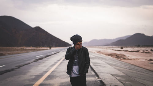 Man standing on road against sky