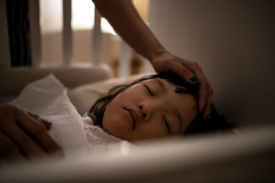 Midsection of woman sleeping on bed at home