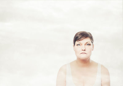 Portrait of sad woman against white background