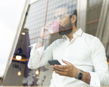 Midsection of man using mobile phone