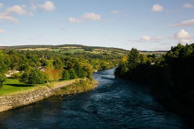 Scenic view of river amidst trees against sky