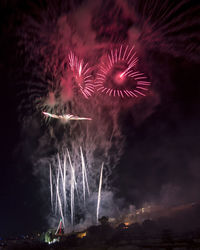 Low angle view of firework display at night