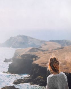 Rear view of woman looking at mountain range against sky