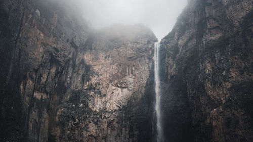 Low angle view of waterfall on mountain