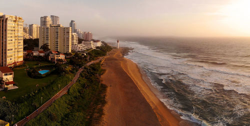 Panoramic view of sea and buildings against sky during sunset