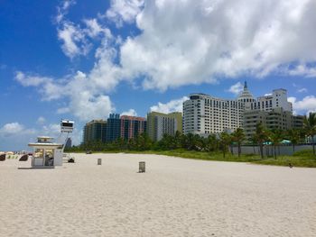 Beach by buildings against sky in city