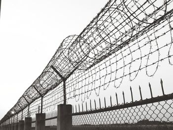 Low angle view of fence against sky