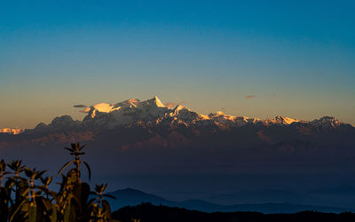 Scenic view of snowcapped mountains against clear sky during sunset