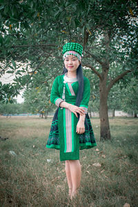 Portrait of girl standing against trees