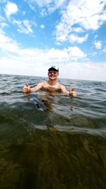 Portrait of shirtless man in sea against sky