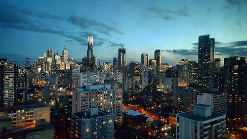 Illuminated cityscape against sky at night