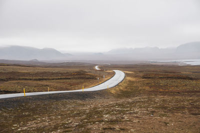 Scenic view of road passing through landscape against sky