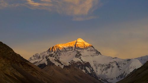 Scenic view of snowcapped mountains against sky during sunset