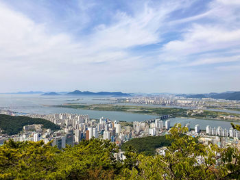 High angle view of townscape by sea against sky