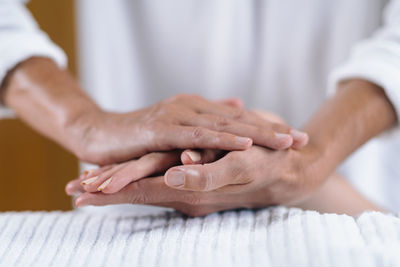 Cropped hands giving massage to women