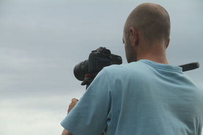 Rear view of man photographing the sea