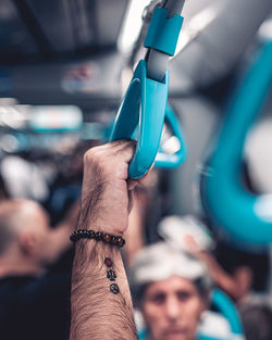 Midsection of man holding umbrella while sitting in bus