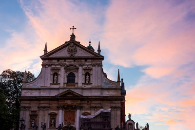 Low angle view of saints peter and paul church against cloudy sky during sunset