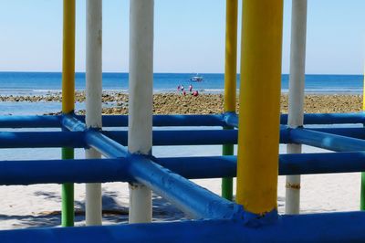 Close-up of railing by sea against sky