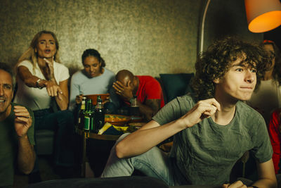 Young couple looking away while sitting on seat