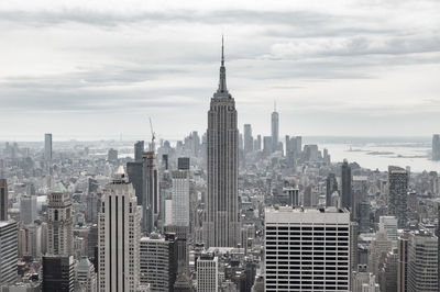 Modern buildings in city against cloudy sky