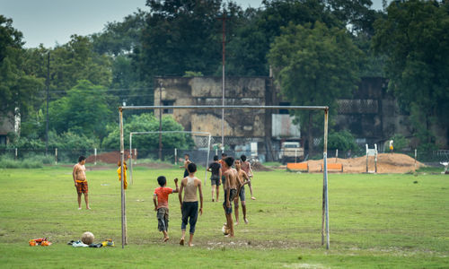 Friends playing soccer on field